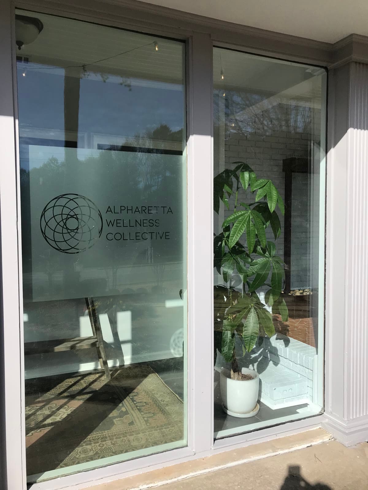 The entrance, with the Alpharetta Wellness Collective mark etched into the glass.